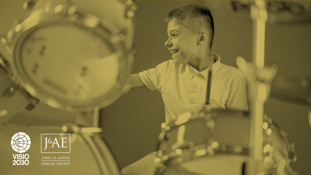 Iloinen poika soittamassa rumpuja