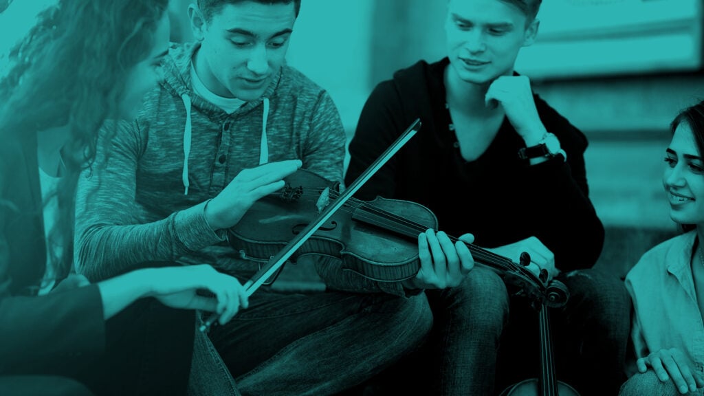 Ihmisiä keskustelemassa viulun ympärillä